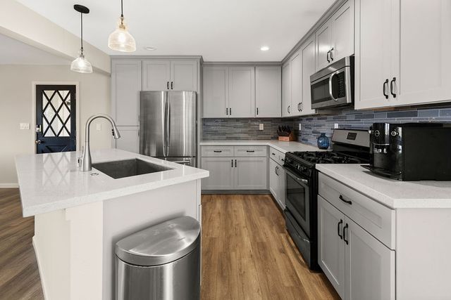 a kitchen with a sink a stove and refrigerator