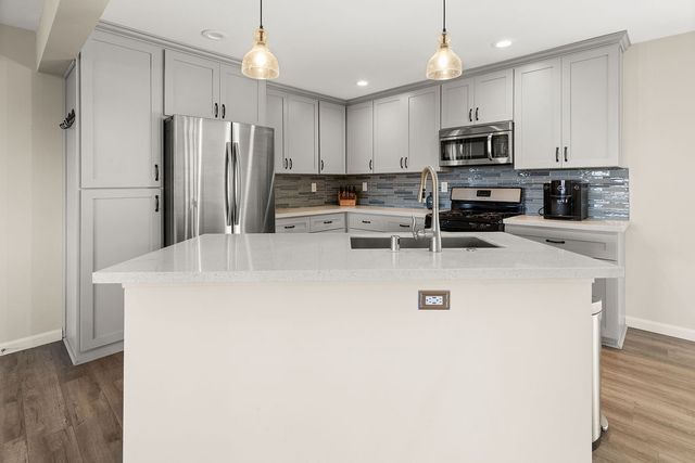 a kitchen with stainless steel appliances a refrigerator sink and microwave