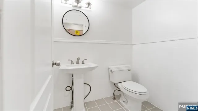 a bathroom with a toilet a sink and a mirror