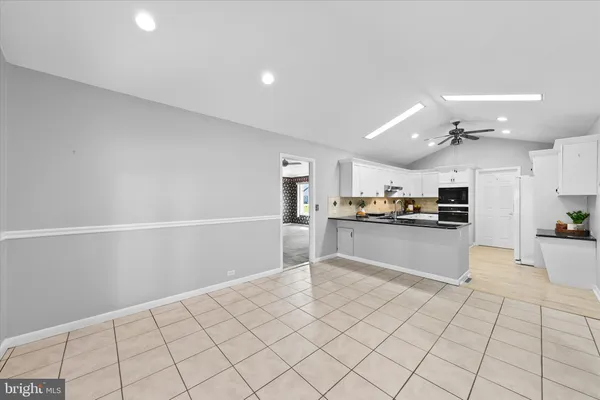 a kitchen with cabinets and chairs
