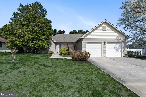 a view of a house with a big yard plants and large tree