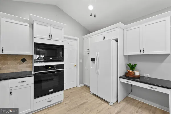 a kitchen with white cabinets and white appliances