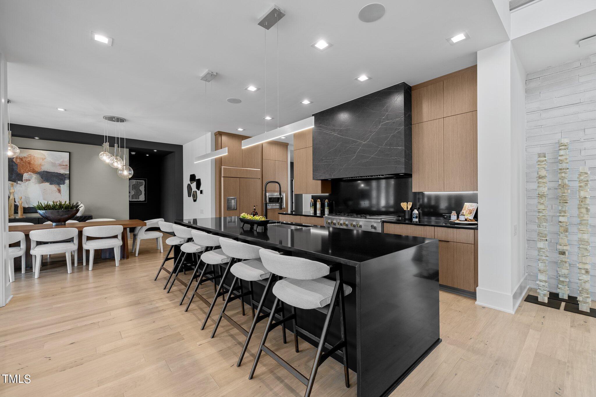 1711 Hunting Ridge Road Raleigh, NC 27615 - Photo 12 of 62 a large dining hall with stainless steel appliances granite countertop a stove a sink a dining table and chairs