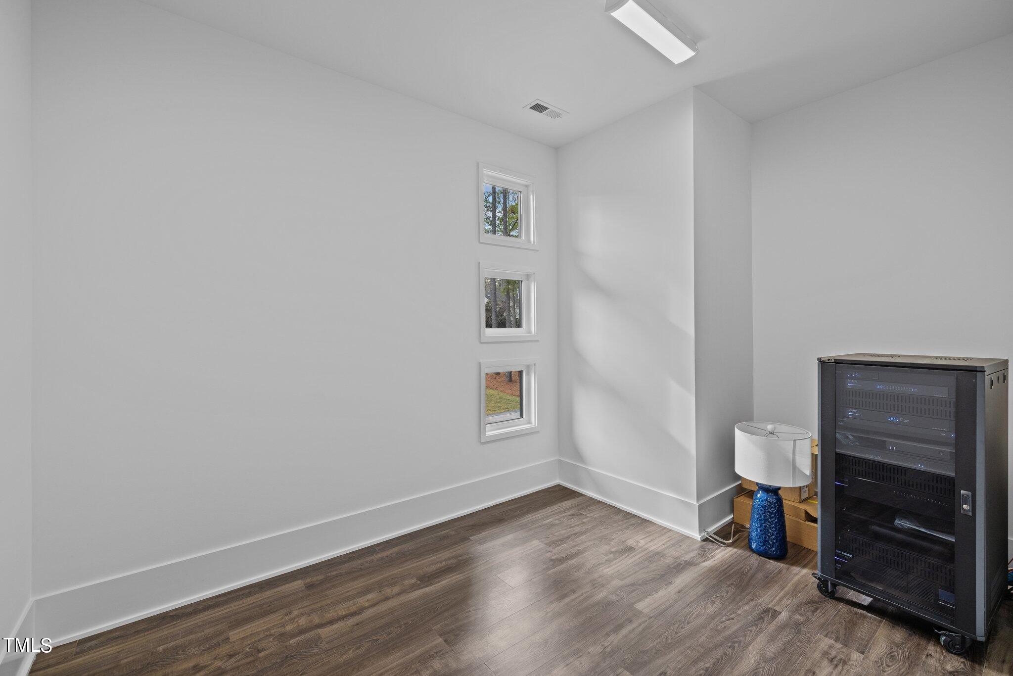 1711 Hunting Ridge Road Raleigh, NC 27615 - Photo 45 of 62 a view of an empty room with a window and wooden floor
