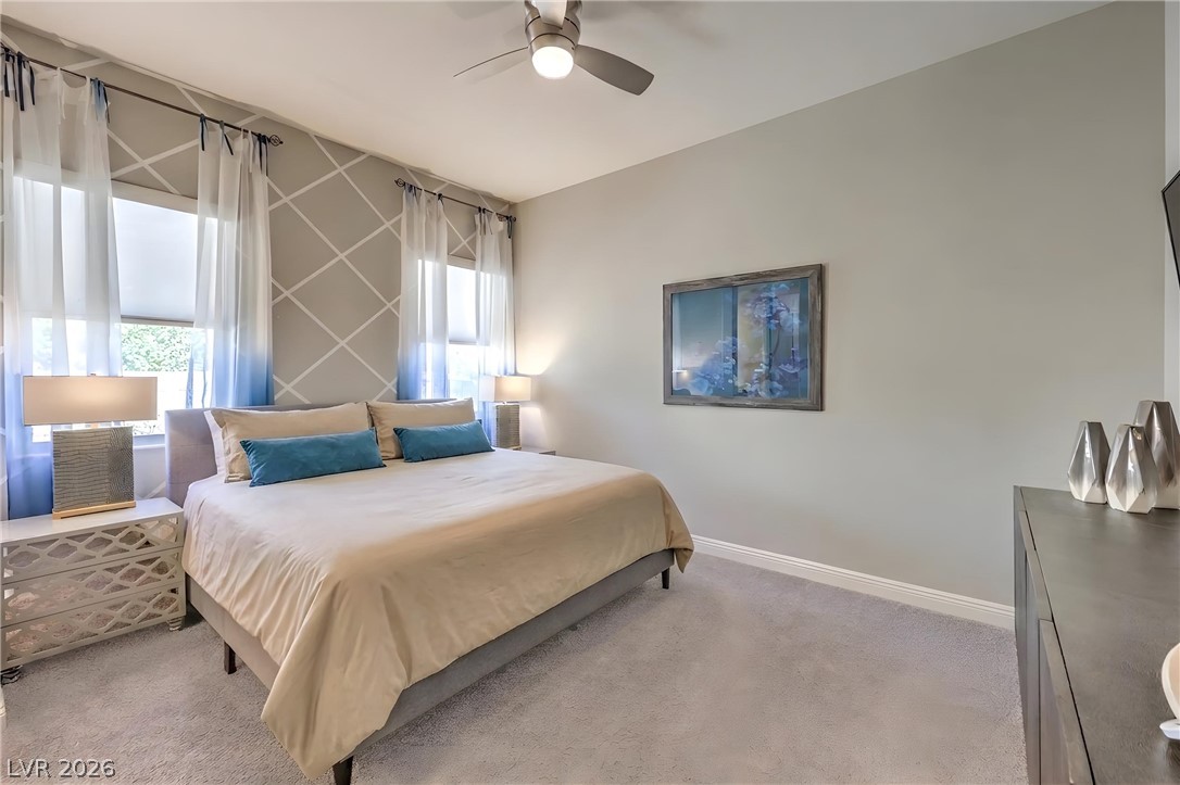 7119 Arabian Ridge Street Las Vegas, NV 89131 - Photo 30 of 73 A well-appointed bedroom features a ceiling fan, plush carpeting, and decorative window treatments for a serene retreat.