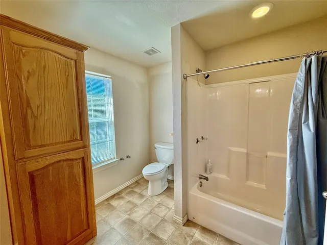 a bathroom with a granite countertop toilet sink and shower