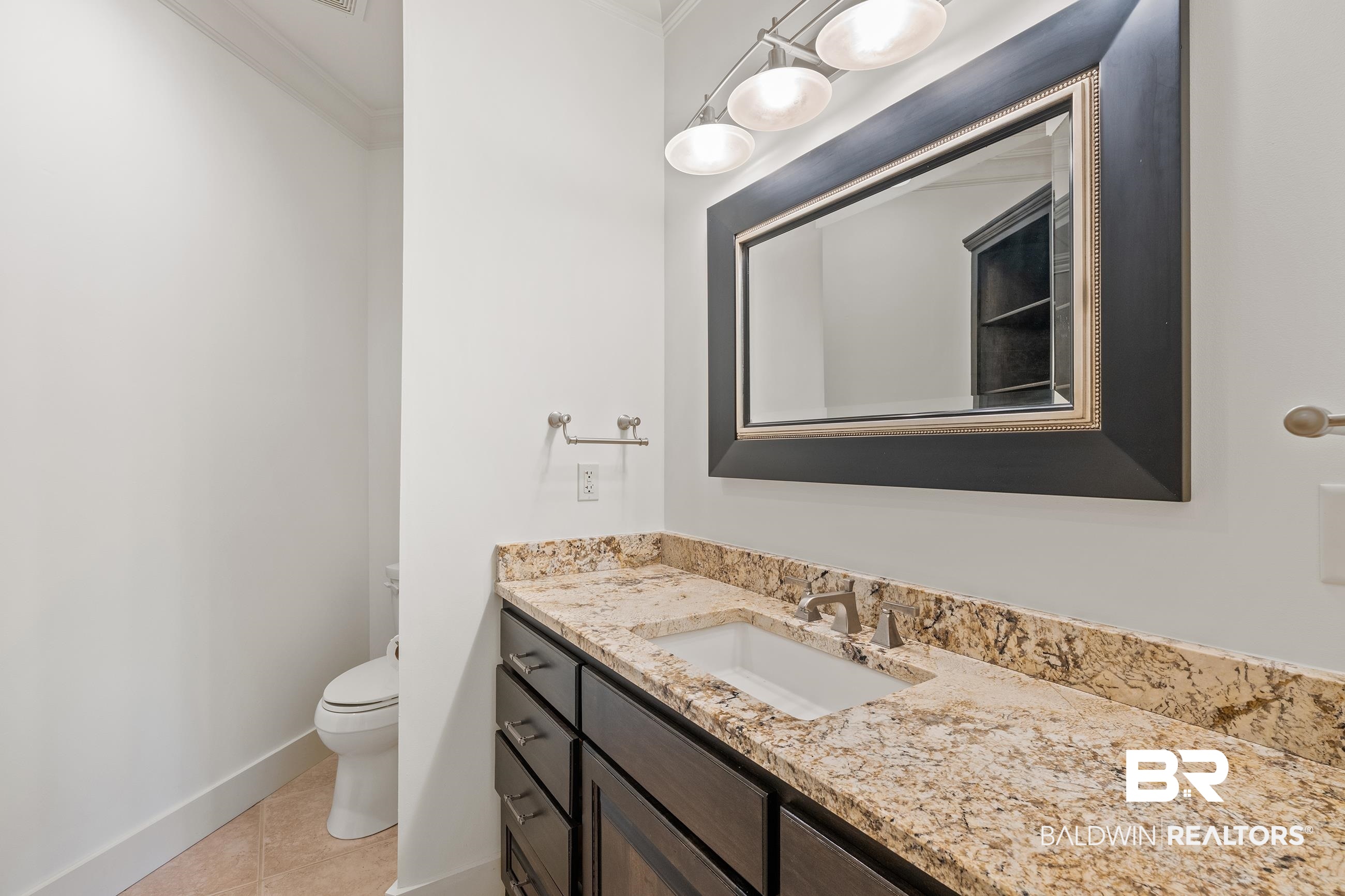 30463 Dolive Ridge Daphne, AL 36527 - Photo 56 of 58 Bathroom vanity featuring a granite countertop, integrated sink, and dark wood cabinetry with brushed nickel hardware