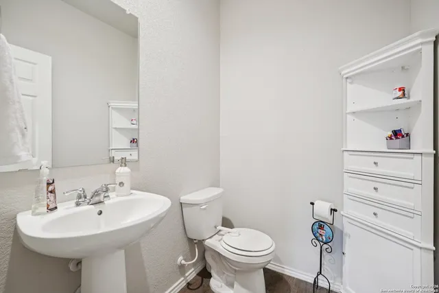 a bathroom with a sink toilet and a mirror