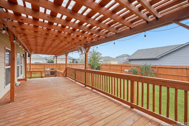 a view of backyard with deck and wooden fence
