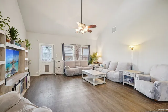 a living room with furniture chandelier and a flat screen tv