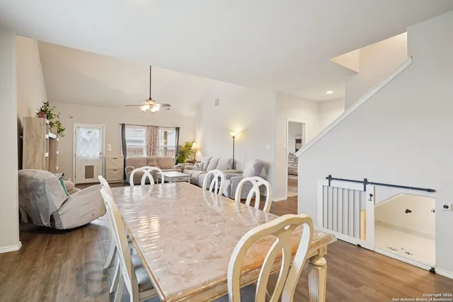a view of a dining room and livingroom with furniture wooden floor a chandelier