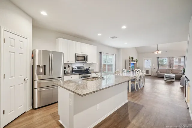 a kitchen with a refrigerator a stove a dining table and chairs
