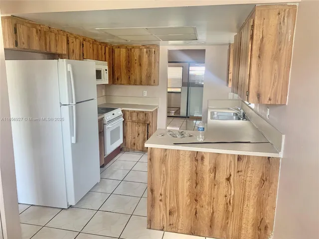 a kitchen with stainless steel appliances granite countertop a refrigerator a stove and a sink