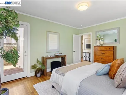 a bedroom with a bed a potted plant and a fireplace