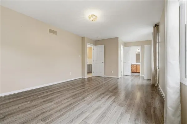 a view of a room with wooden floor and a bathroom
