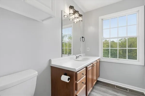 a bathroom with a sink a toilet and a window