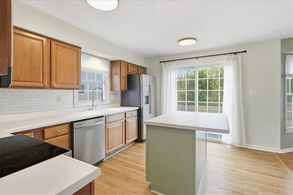 a kitchen with stainless steel appliances granite countertop a sink a stove a refrigerator and cabinets