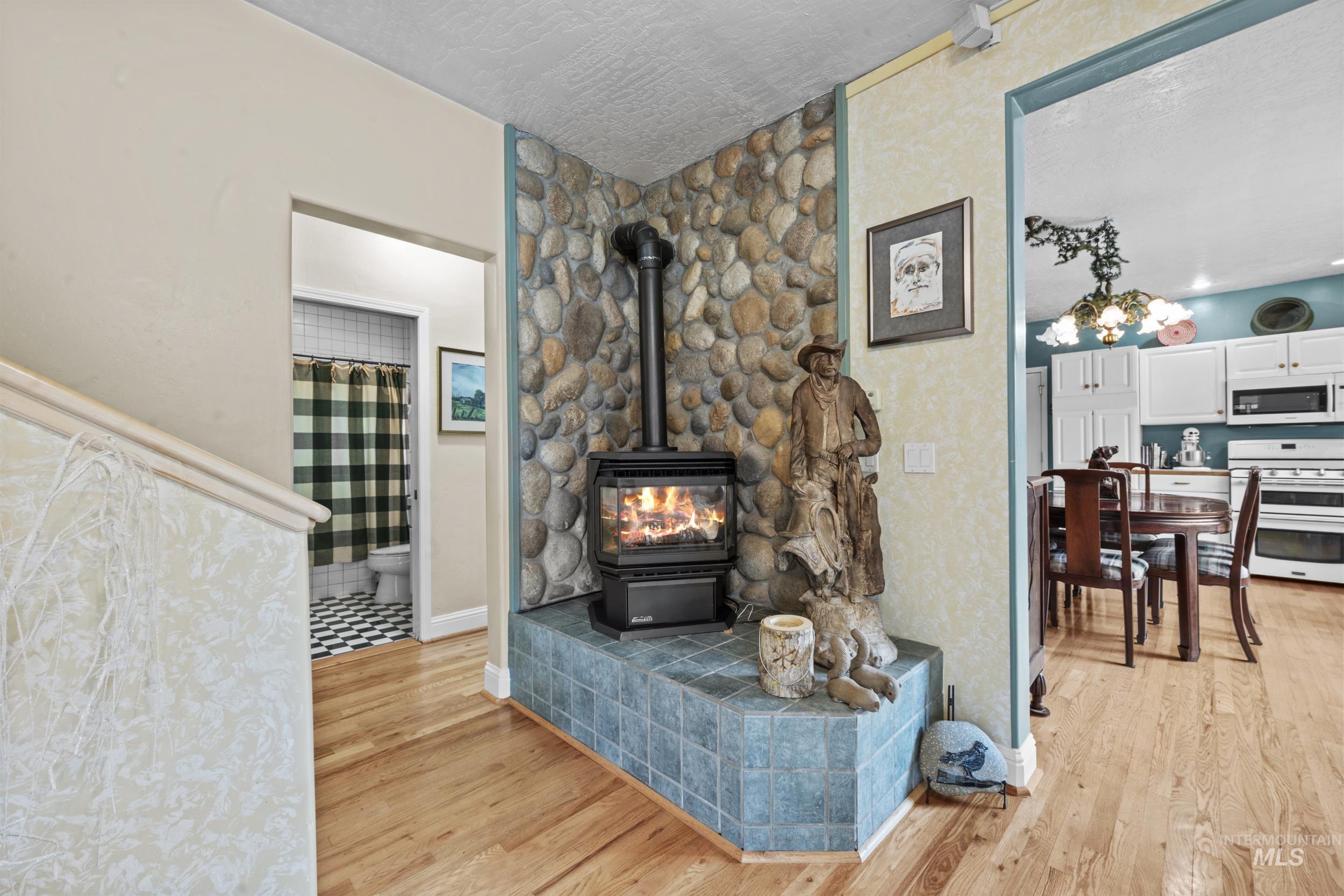 69 River Ranch Road Garden Valley, ID 83622 - Photo 11 of 50 Living area featuring light wood-style floors, a wood stove, and a textured ceiling