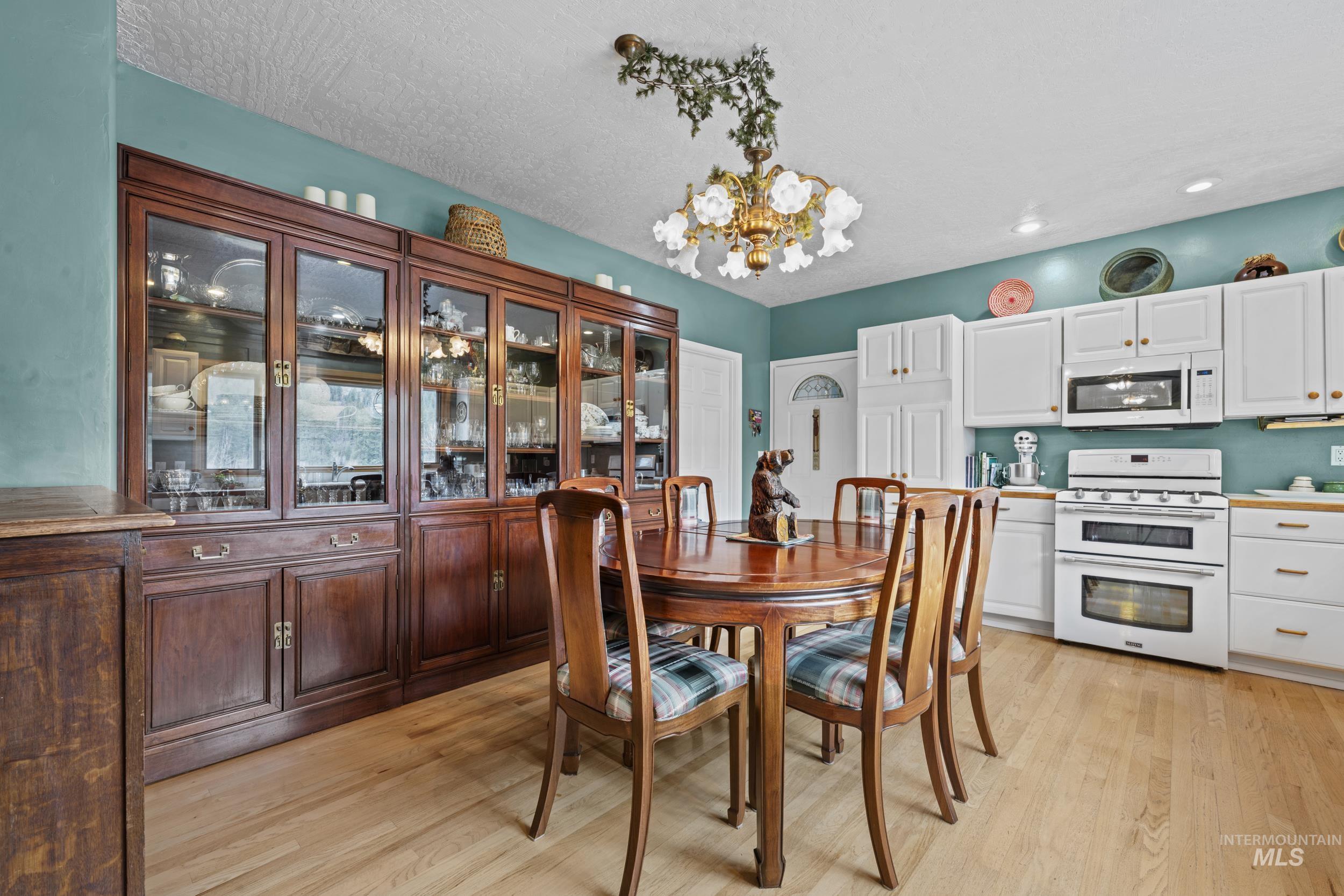 69 River Ranch Road Garden Valley, ID 83622 - Photo 13 of 50 Dining room with hanging lights, light wood-type flooring, and a textured ceiling
