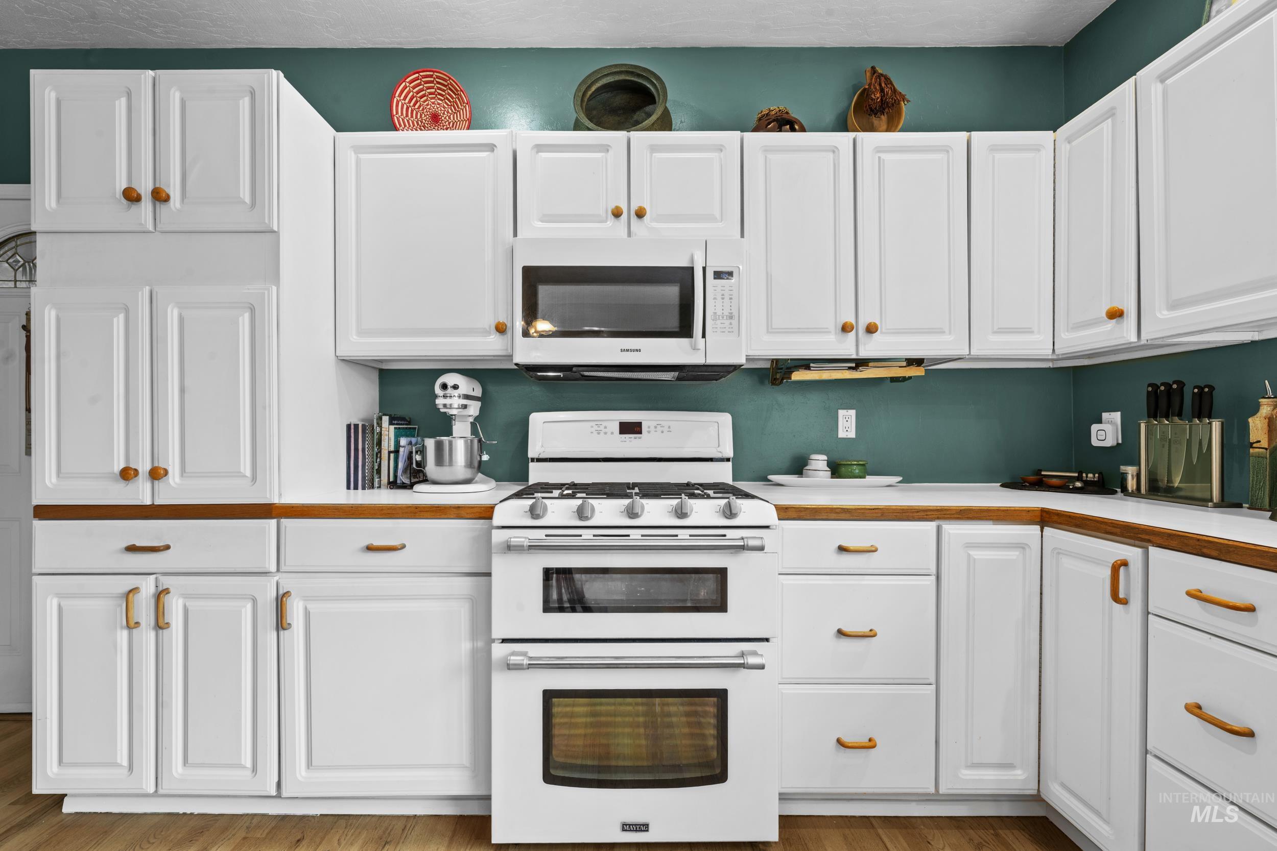 69 River Ranch Road Garden Valley, ID 83622 - Photo 15 of 50 Kitchen featuring white appliances, light countertops, and white cabinetry