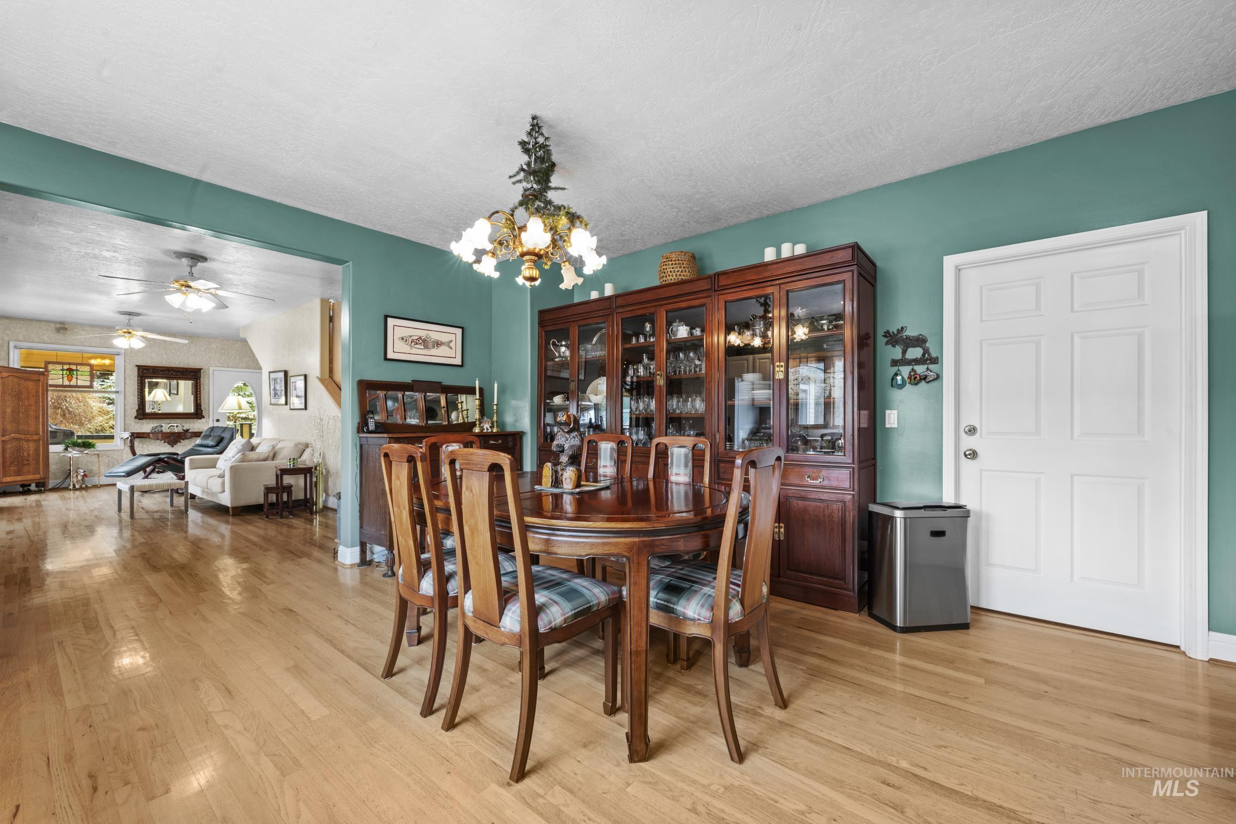 69 River Ranch Road Garden Valley, ID 83622 - Photo 17 of 50 Dining area with a chandelier, a ceiling fan, light wood-type flooring, and a textured ceiling