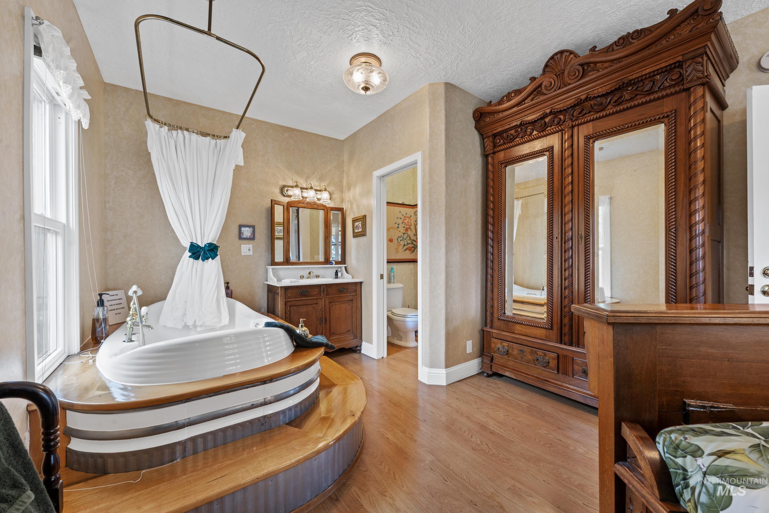 69 River Ranch Road Garden Valley, ID 83622 - Photo 19 of 50 Full bath featuring vanity, a bath, light wood-type flooring, and a textured ceiling