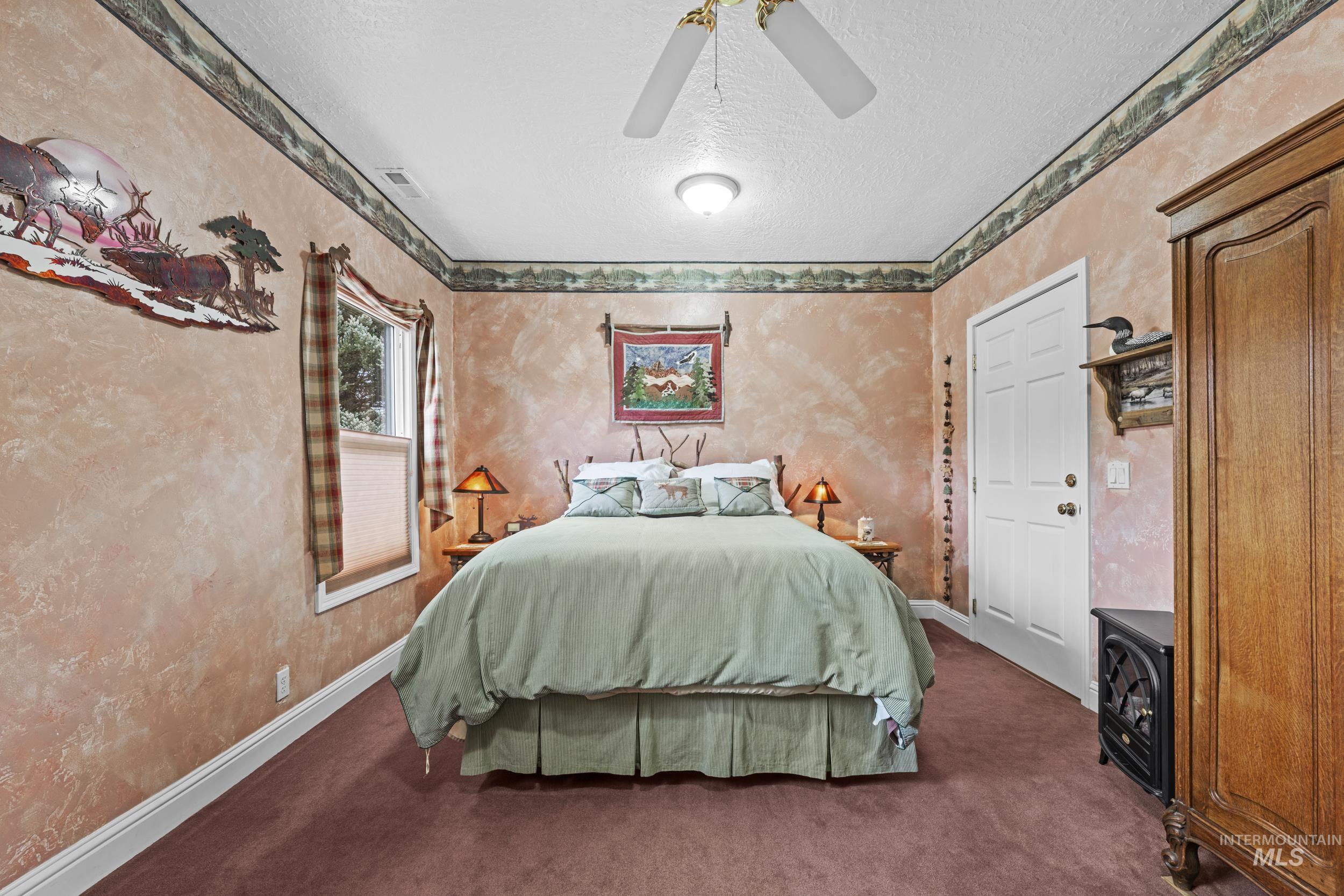 69 River Ranch Road Garden Valley, ID 83622 - Photo 20 of 50 Bedroom featuring a textured ceiling, carpet, ceiling fan, and wallpapered walls