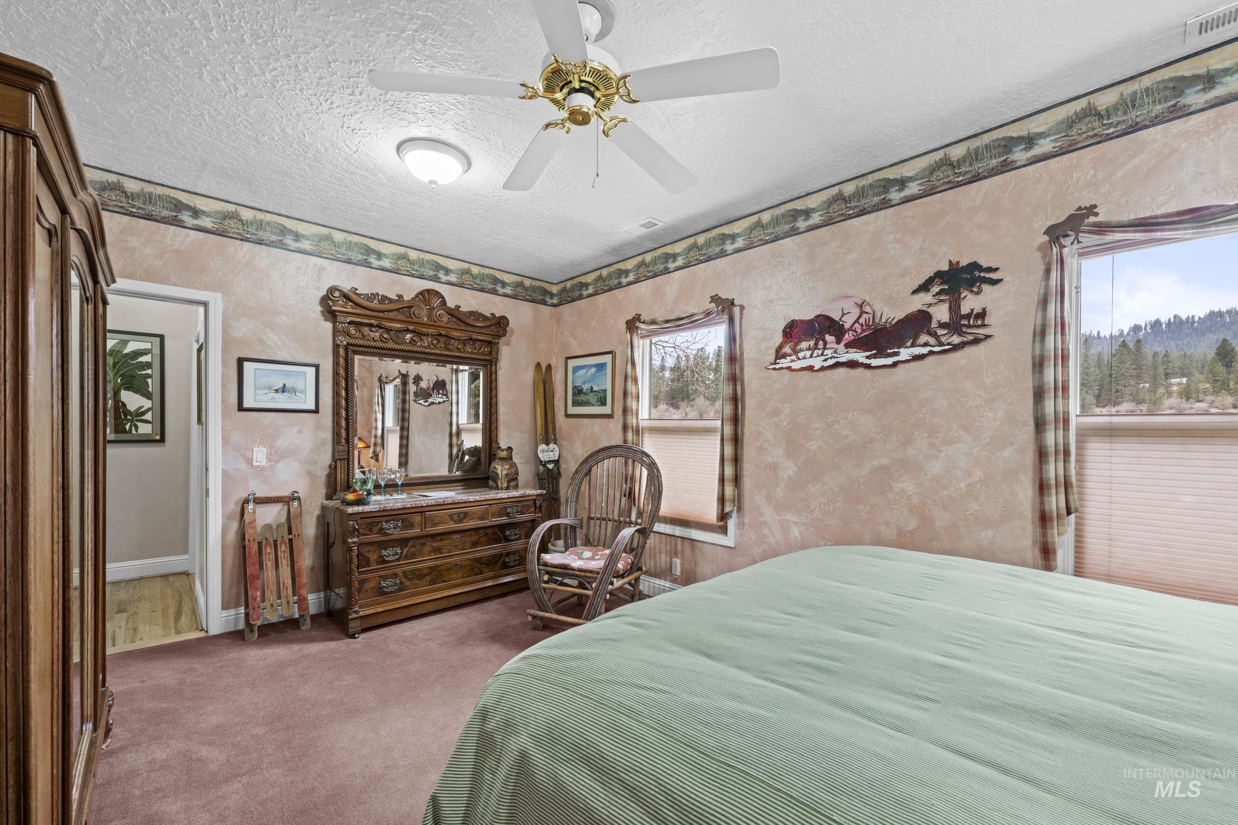 69 River Ranch Road Garden Valley, ID 83622 - Photo 21 of 50 Bedroom with a ceiling fan, a textured ceiling, and dark colored carpet