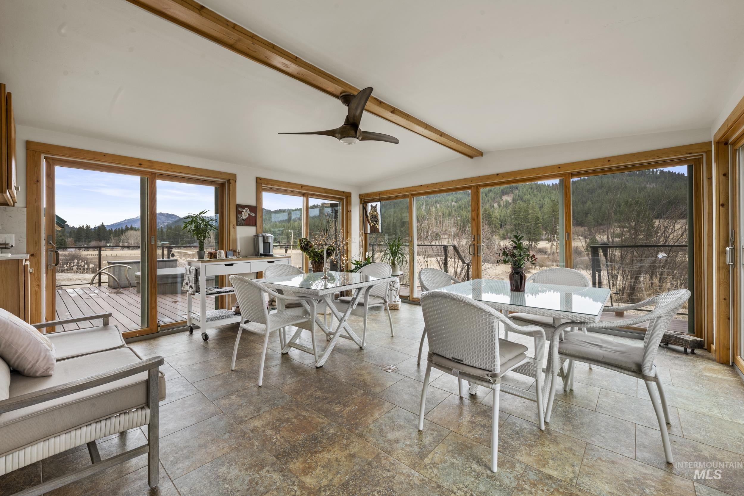 69 River Ranch Road Garden Valley, ID 83622 - Photo 33 of 50 Sunroom / solarium featuring stone tile flooring, a mountain view, and vaulted ceiling with beams