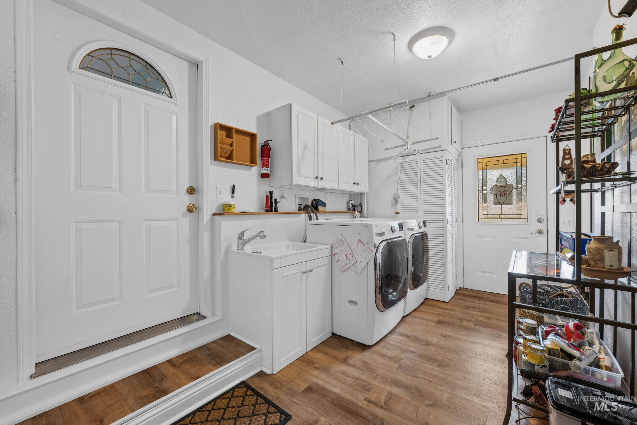 69 River Ranch Road Garden Valley, ID 83622 - Photo 36 of 50 Laundry room with light wood-type flooring, independent washer and dryer, and cabinet space