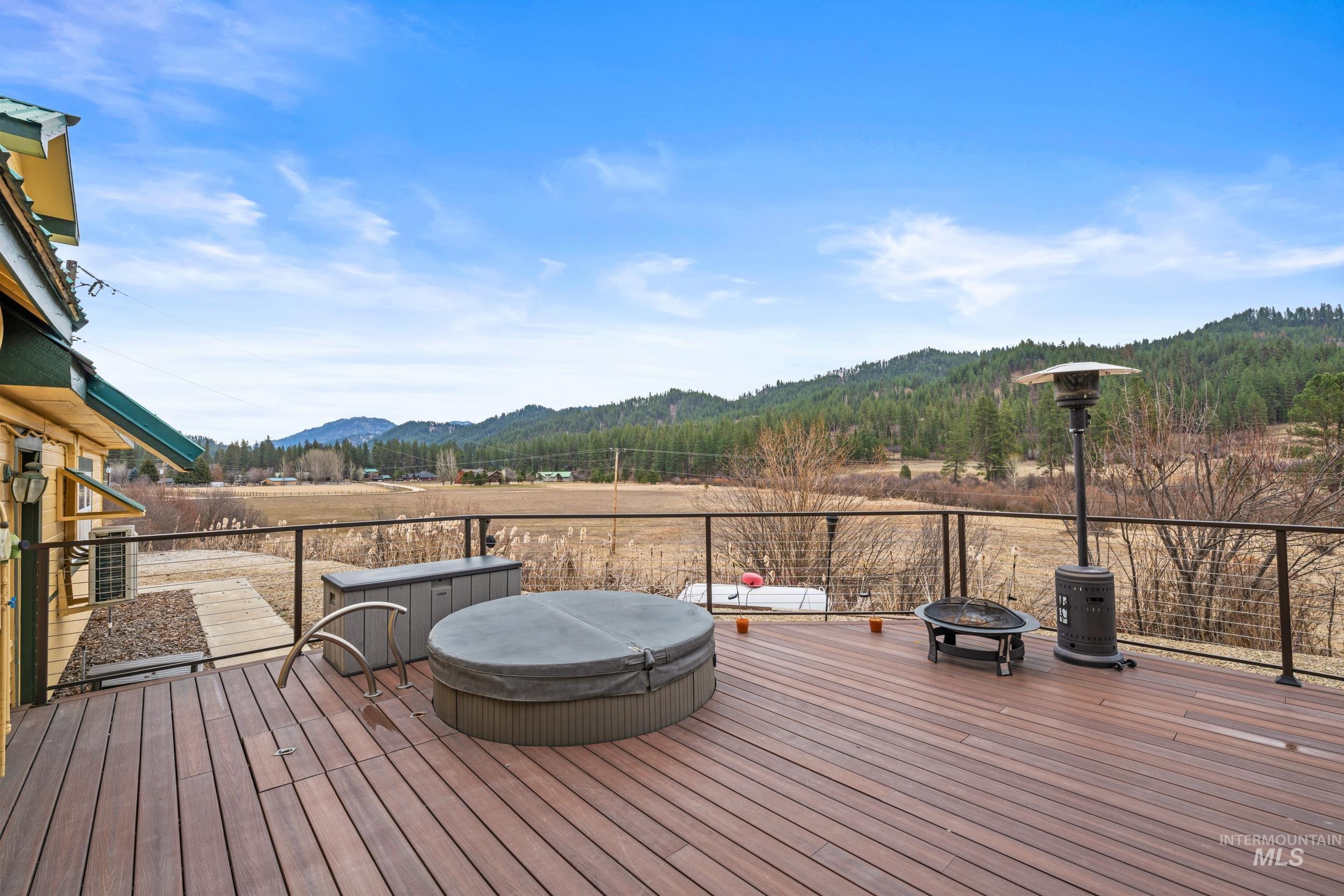 69 River Ranch Road Garden Valley, ID 83622 - Photo 41 of 50 Wooden terrace featuring a covered hot tub, a fire pit, and a mountain view