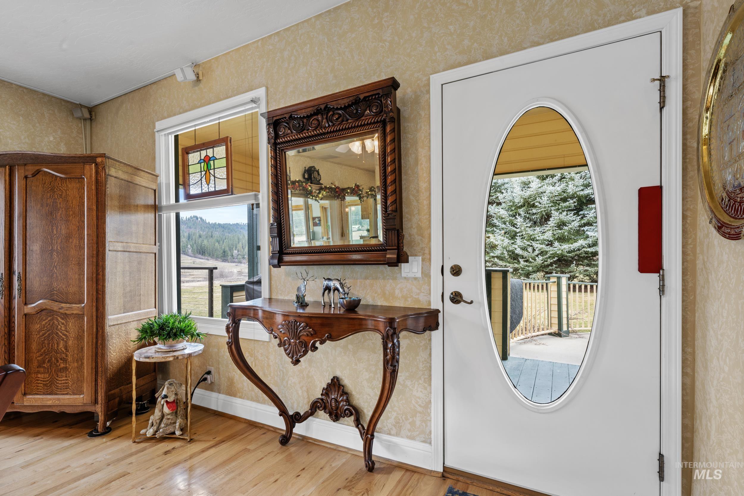 69 River Ranch Road Garden Valley, ID 83622 - Photo 5 of 50 Entrance foyer featuring wallpapered walls, light wood-type flooring, and plenty of natural light