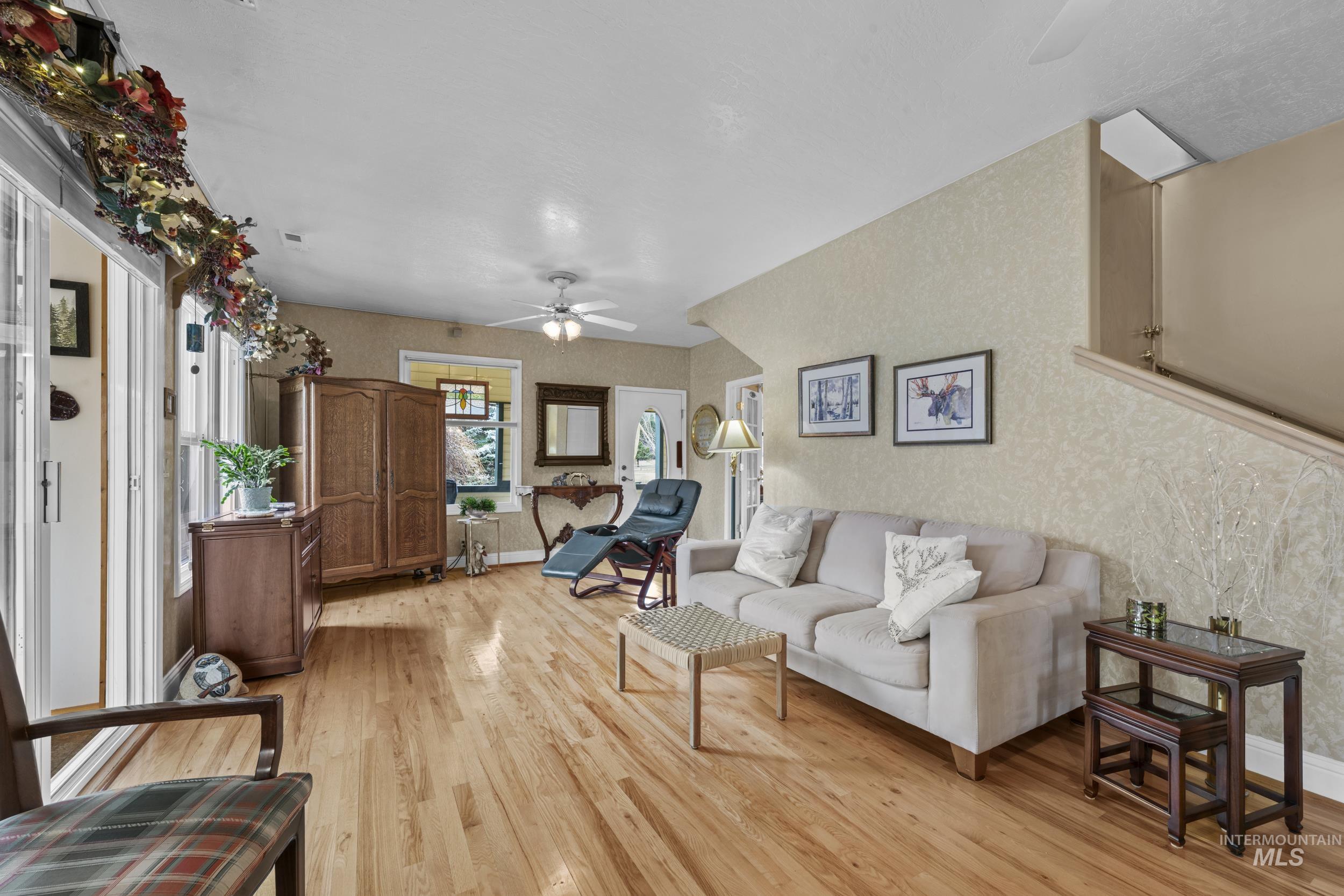 69 River Ranch Road Garden Valley, ID 83622 - Photo 6 of 50 Living room featuring ceiling fan, light wood-style floors, and wallpapered walls