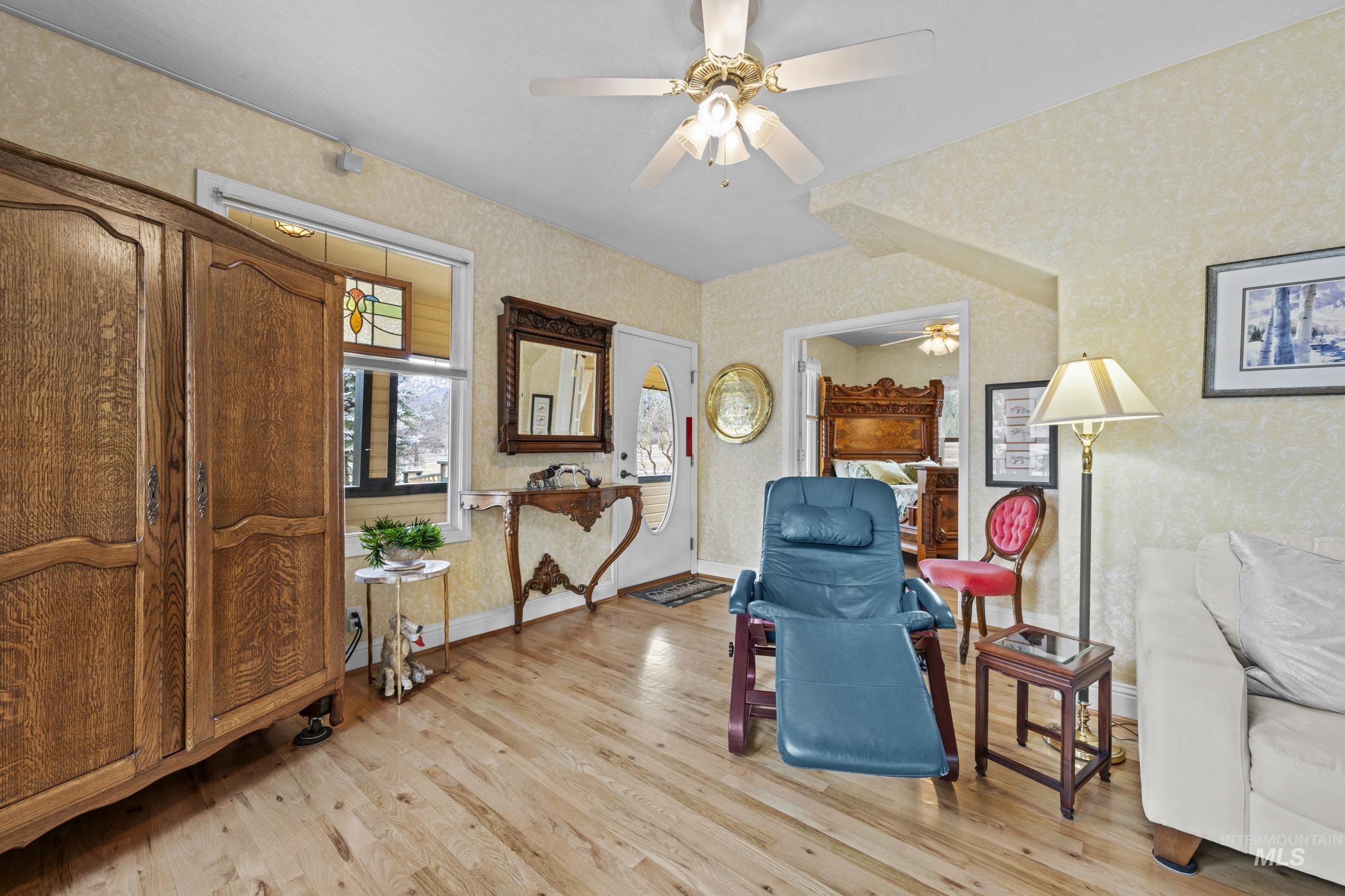69 River Ranch Road Garden Valley, ID 83622 - Photo 9 of 50 Living area featuring light wood-style flooring, ceiling fan, and wallpapered walls