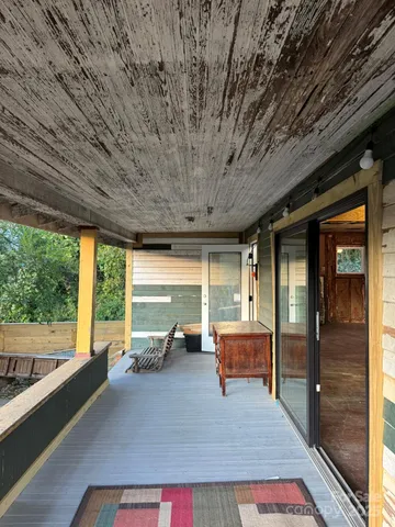 a living room with furniture stove and large windows