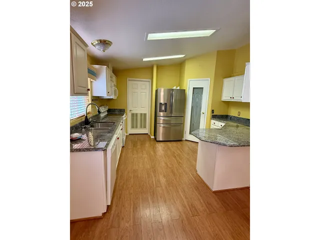 a kitchen with stainless steel appliances granite countertop a refrigerator and a stove top oven