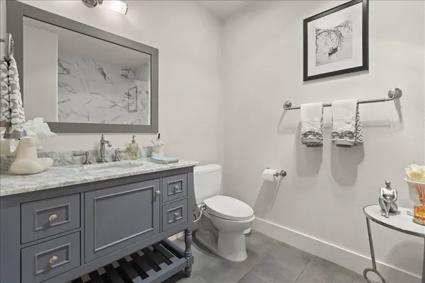 a bathroom with a granite countertop sink a toilet and a mirror