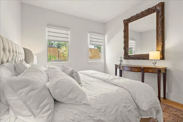 a bedroom with a bed a mirror and a window