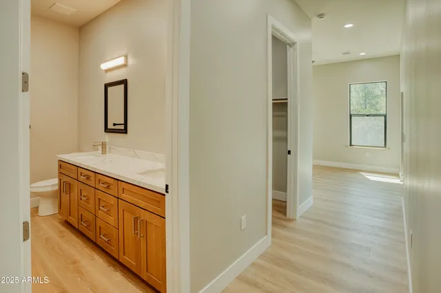 a hallway with wooden floor and mirror