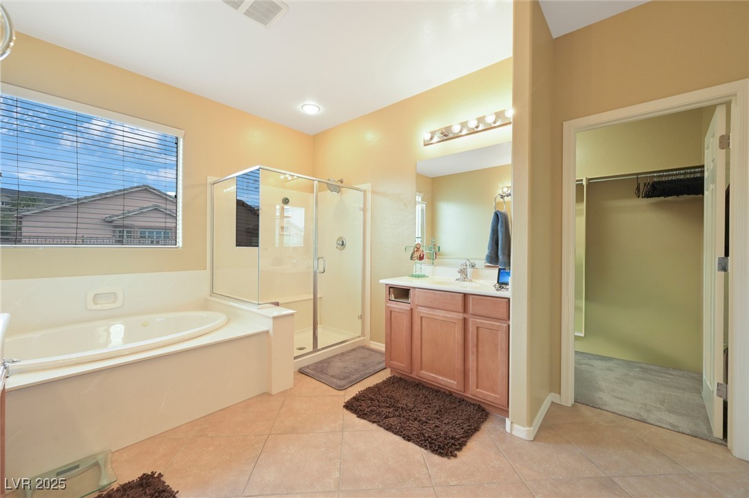2289 Manosque Lane Henderson, NV 89044 - Photo 12 of 35 Full bath featuring a stall shower, vanity, a garden tub, light tile patterned floors, and a walk in closet