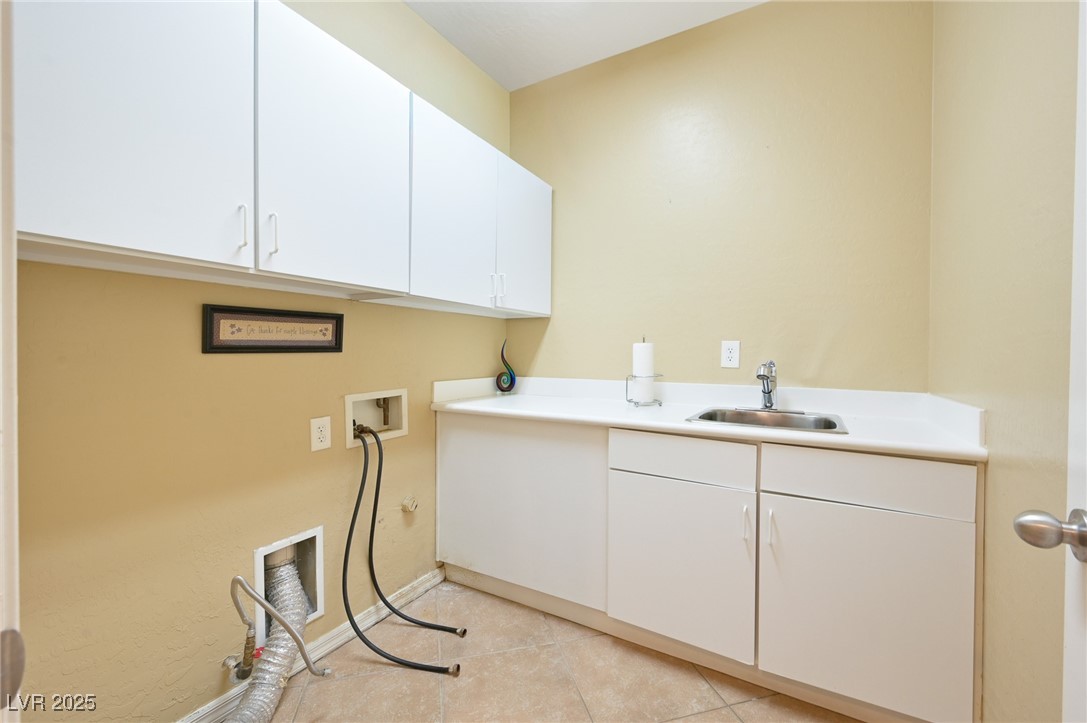 2289 Manosque Lane Henderson, NV 89044 - Photo 18 of 35 Laundry area with cabinet space, washer hookup, and light tile patterned floors