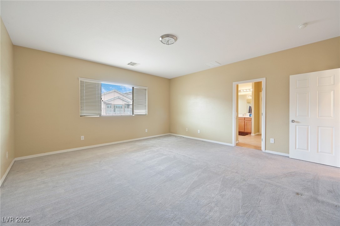 2289 Manosque Lane Henderson, NV 89044 - Photo 24 of 35 Unfurnished bedroom featuring light colored carpet and connected bathroom