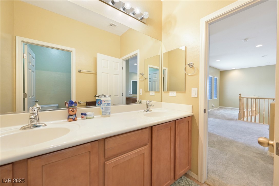 2289 Manosque Lane Henderson, NV 89044 - Photo 26 of 35 Bathroom with double vanity, light colored carpet, and recessed lighting