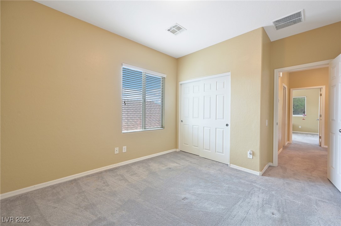2289 Manosque Lane Henderson, NV 89044 - Photo 29 of 35 Unfurnished bedroom featuring carpet, multiple windows, and a closet