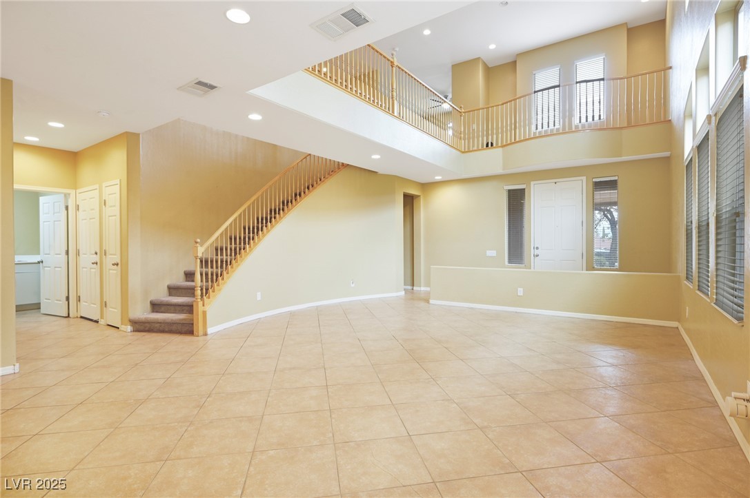 2289 Manosque Lane Henderson, NV 89044 - Photo 5 of 35 Unfurnished living room featuring stairway, recessed lighting, light tile patterned floors, and a high ceiling