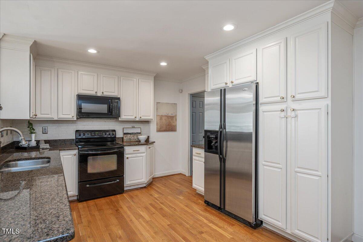821 Macon Place Raleigh, NC 27609 - Photo 14 of 32 a kitchen with stainless steel appliances granite countertop a refrigerator a stove a sink and a microwave