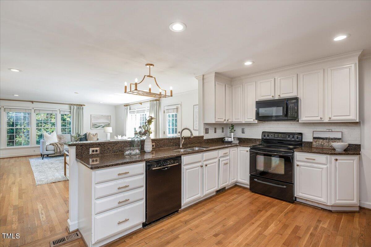 821 Macon Place Raleigh, NC 27609 - Photo 17 of 32 a kitchen with stainless steel appliances granite countertop a stove and a sink
