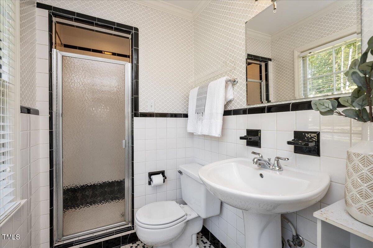 821 Macon Place Raleigh, NC 27609 - Photo 21 of 32 a bathroom with a sink a toilet and a mirror