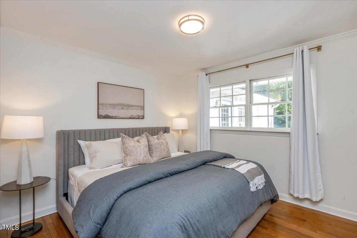 821 Macon Place Raleigh, NC 27609 - Photo 22 of 32 a bedroom with a bed and a lamp