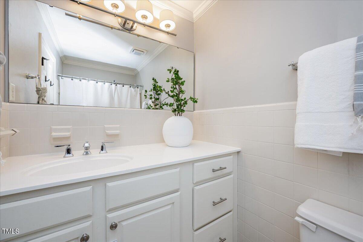 821 Macon Place Raleigh, NC 27609 - Photo 23 of 32 a bathroom with a sink a vanity and a mirror